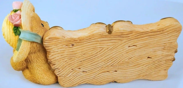Decorative resin Figurine with a textured surface and a small decorative item on top against a light blue background.