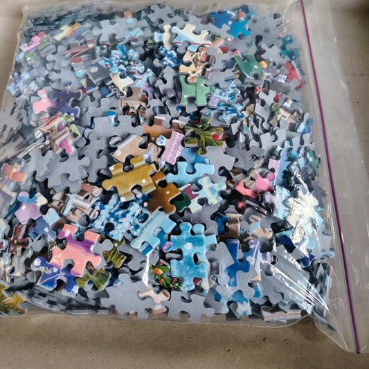 Assorted puzzle pieces in a clear plastic bag on a cardboard surface