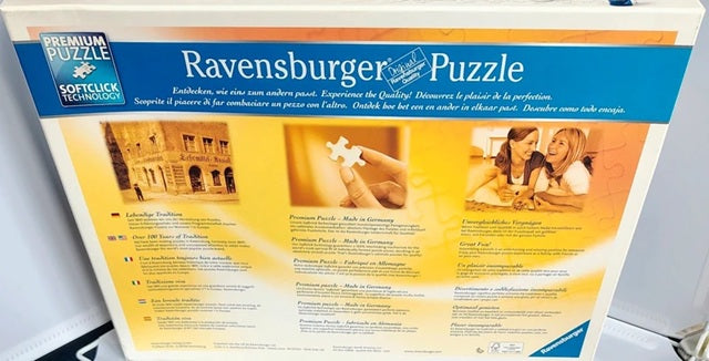 Ravensburger puzzle packaging with a couple and building illustration on a white background