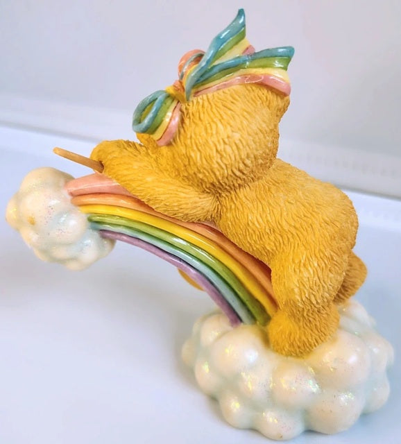 Colorful teddy bear figurine with rainbow and butterfly on a white background