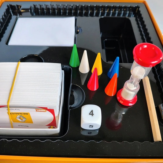 Board game components including cards, dice, and colorful markers on a black tray.