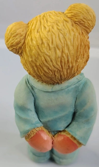 Teddy bear figurine wearing a blue sweater on a white background