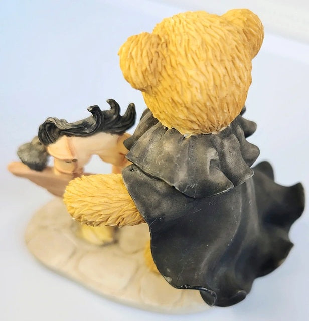 Figurine of Cherished Teddies Icabod with a large yellow hat and dark clothing on a light blue background