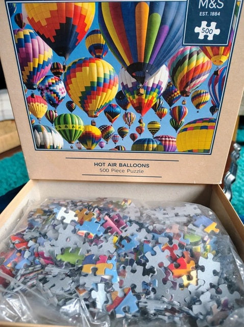 M&S hot air balloons puzzle with pieces missing, showing colorful design on box.
