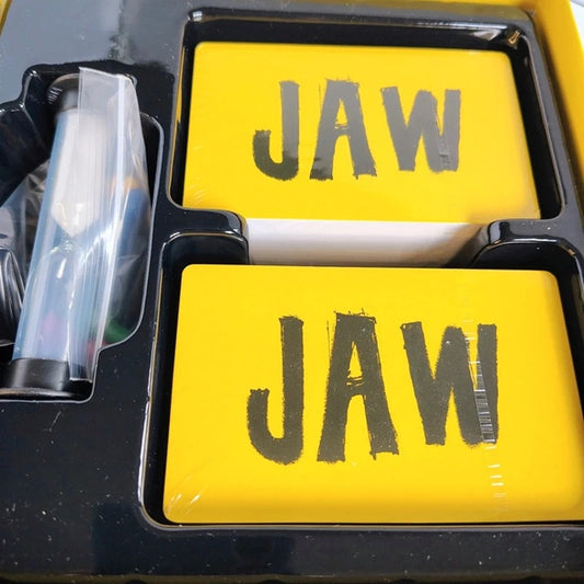 Yellow game cards with 'JAW' text in a black tray