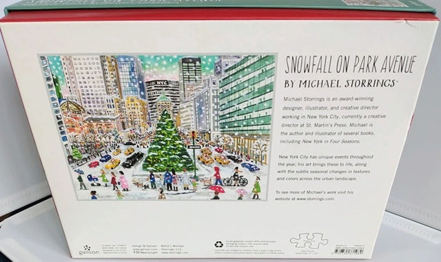 Back of a puzzle box with a colorful illustration of a snowy city scene and text about Michael Storrings.