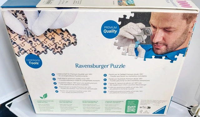 Ravensburger puzzle box with a man assembling a puzzle piece.