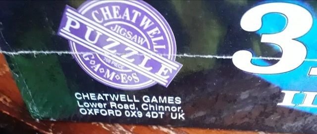 Cheatwell Games jigsaw puzzle packaging with branding and address information.