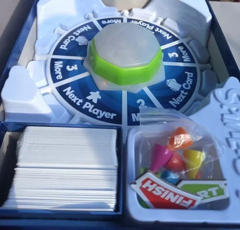 Game components including cards and game pieces in a box