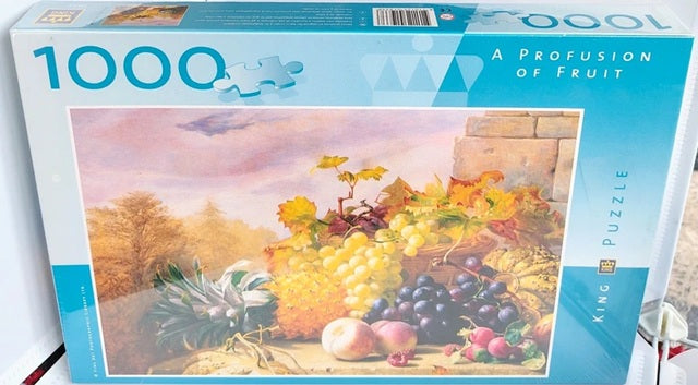 Jigsaw puzzle box titled 'A Profusion of Fruit' with a scenic depiction on the cover.