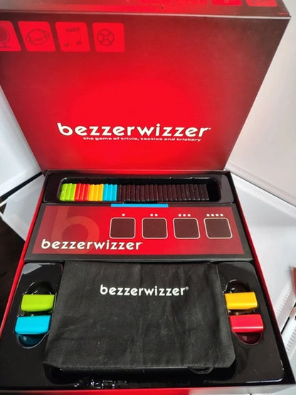 Bezzerwizzer game set shown open in its red retail box, with the game board, colored pieces, and a black branded carrying pouch visible.