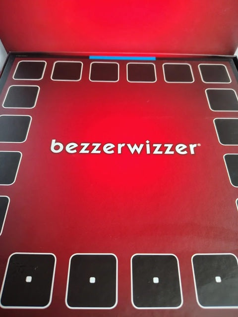 The red and black packaging box for the game 'bezzewizzer', featuring the white brand name in the center and black squares outlining the play area.