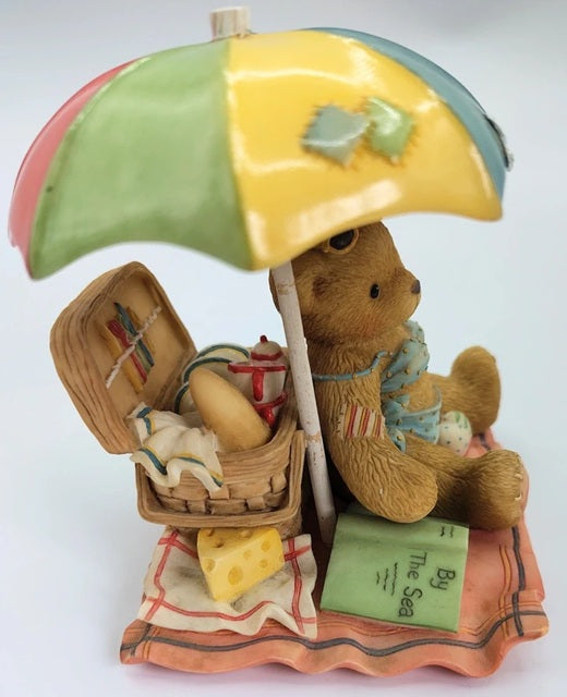 Cherished Teddy bear with a colorful umbrella, picnic basket, and beach towel on a white background