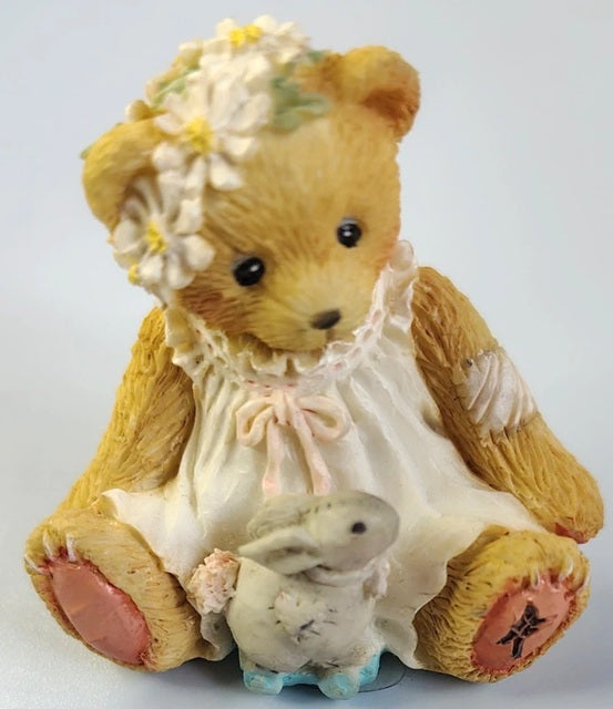 Cherished Teddies Spring bear in a white dress holding a rabbit, wearing a floral headband on a light gray background. 916358.
