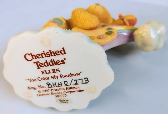 Decorative item with 'Cherished Teddies' branding and product details on a light blue background.