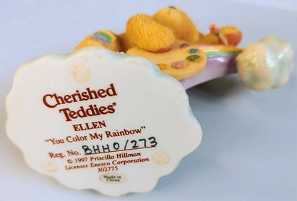 Decorative item with 'Cherished Teddies' branding and product details on a light blue background.