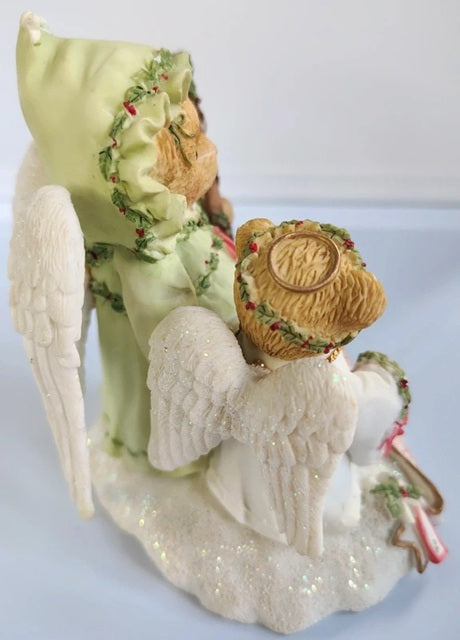 Decorative angel figurine with a hat and floral headband on a light background