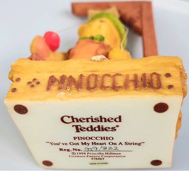 Pinocchio figurine with 'Cherished Teddies' branding on a white background