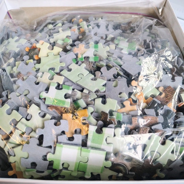 Box of jigsaw puzzle pieces with a mix of colors and animal designs.