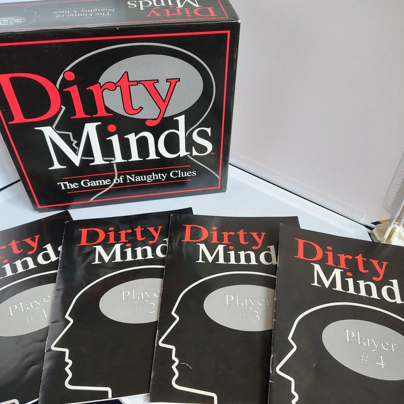 Board game packaging for 'Dirty Minds' with player cards on a light surface.