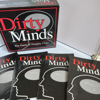 Board game packaging for 'Dirty Minds' with player cards on a light surface.