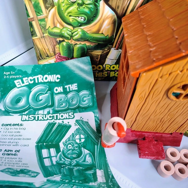 Toy set with 'Electronic Og on the Bog' instructions and toy components on a white surface