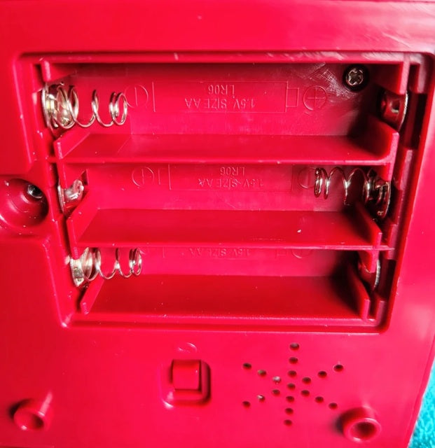 Close-up of a red mechanical component with springs and metal parts.