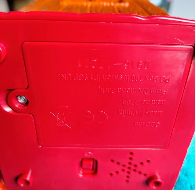Close-up of a red plastic component with text and symbols on it.