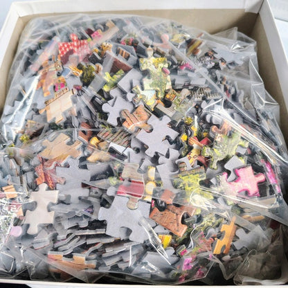 Pile of puzzle pieces in a box with clear plastic bags.