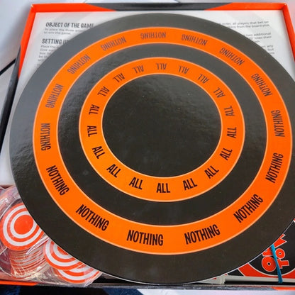Circular game board with concentric rings and text, likely from a board game, on top of a box.