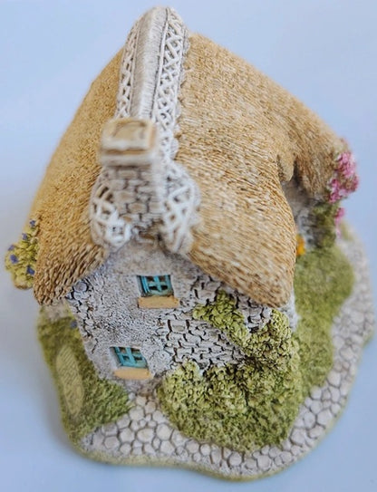 Textured model of a house with a thatched roof on a light blue background