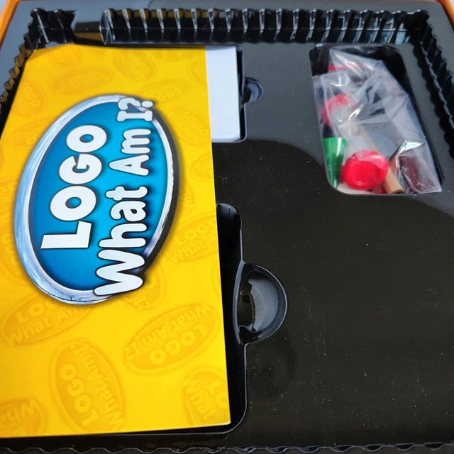 Logo 'What Am I?' game packaging with yellow and black design