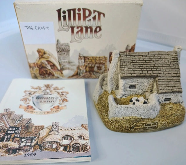 Lilliput Lane model of a cottage with packaging and booklet on a light background