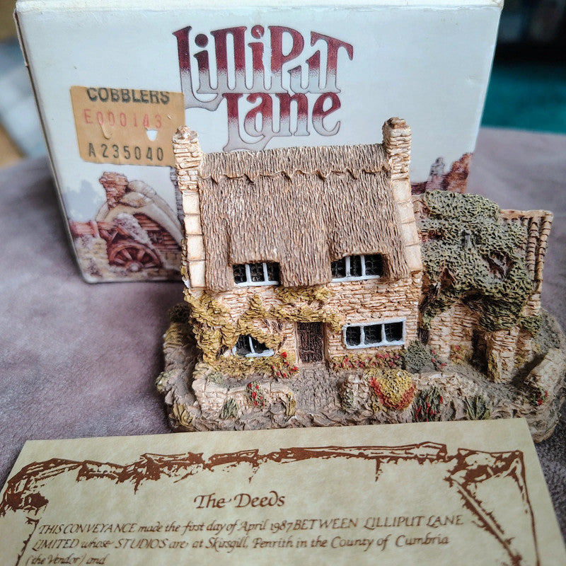 Miniature model of a thatched cottage with 'Lilliput Lane' branding and packaging.