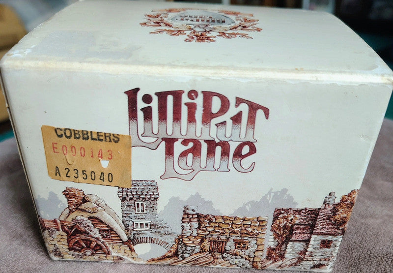Box with 'Lilliput Lane' branding and architectural illustrations on a textured surface.