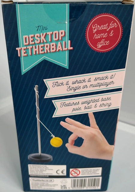 Box for a mini desktop tetherball game with text and a hand illustration.