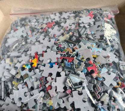 Pile of puzzle pieces in a clear plastic bag on a cardboard surface