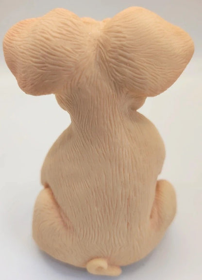 A beige figurine of a pig seen from the back, featuring detailed fur texture and ears, set against a plain white background.