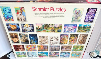 Schmidt Puzzles jigsaw puzzle collection box showing a grid of various colorful puzzle cover images on a white box.