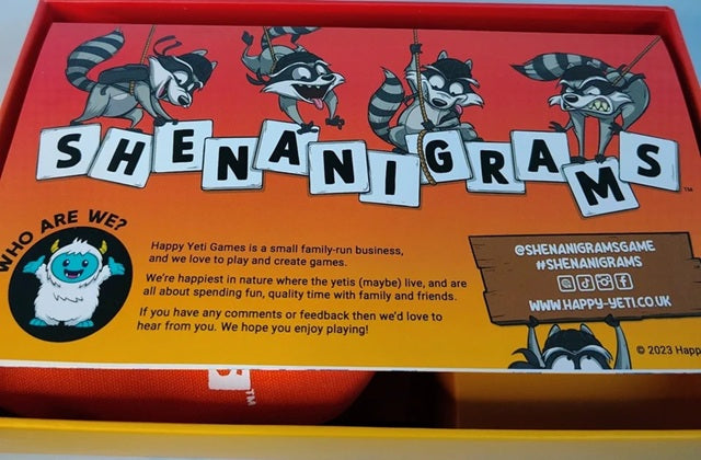 Shenanigans board game box with cartoon raccoons and Happy Yeti Games branding.