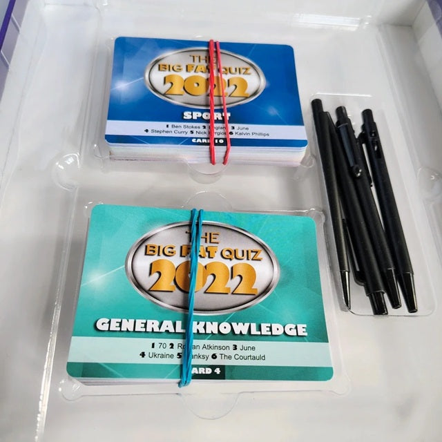 Two quiz sets of question cards titled 'The Big Fast Quiz 2022' for Sport and General Knowledge, with pens on a white surface.