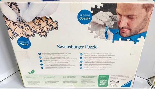 Ravensburger puzzle box with a man assembling a puzzle piece.