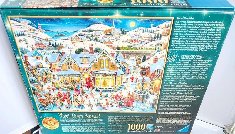 A 1000-piece jigsaw puzzle box featuring a detailed winter village scene with snow-covered houses, people, Santa, and mountains under a starry night sky. The box is photographed on a light surface with some surrounding room elements visible.