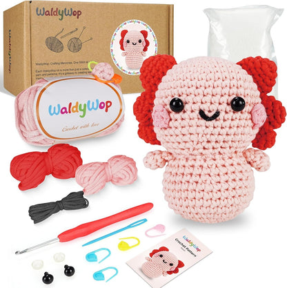 WaldyWop Newt Crochet kit with a completed amigurumi toy, yarn, hooks, and patterns on a white background.