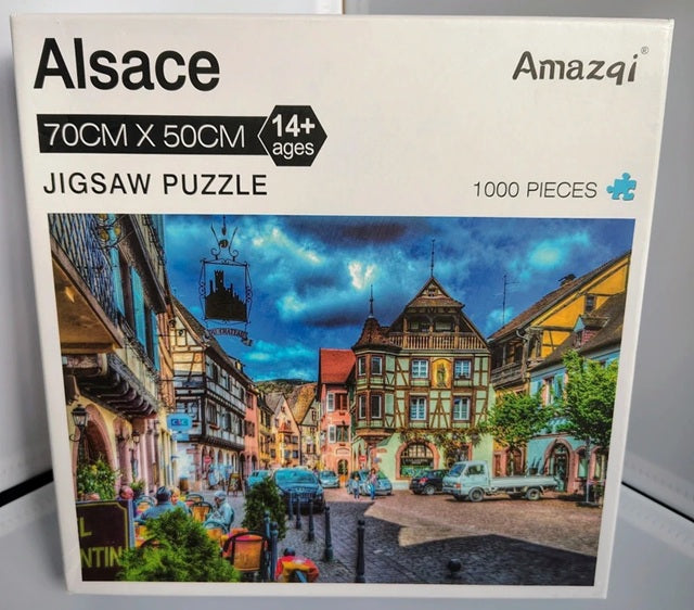 Jigsaw puzzle box with a colorful town scene and 'Alsace' branding.