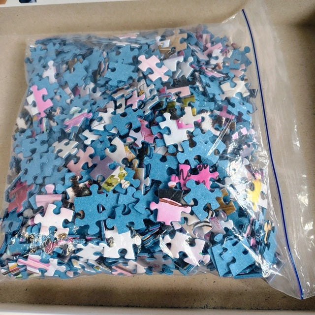 Bag of assorted puzzle pieces on a cardboard surface
