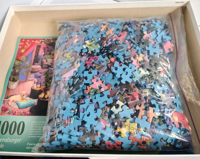 Jigsaw puzzle in a box with a partially completed puzzle and packaging visible.
