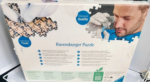 Ravensburger puzzle box with a man assembling a puzzle piece.