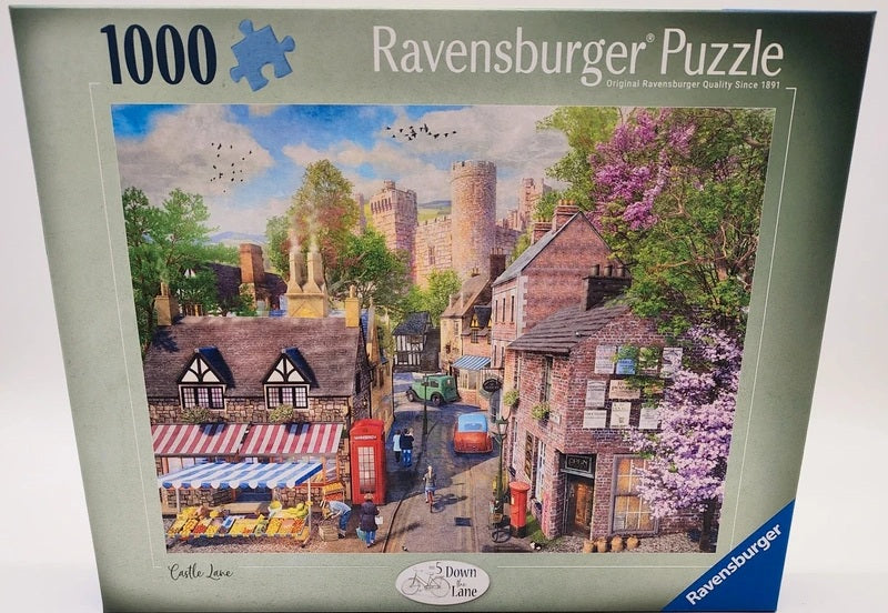 Ravensburger Castle Lane 1000-piece jigsaw puzzle box featuring a colourful illustration of a village street with brick buildings, a red phone booth, and a castle in the background.