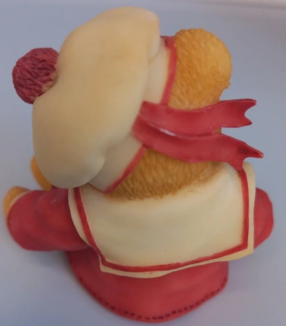 Toy figure of a character with a red outfit and yellow head on a white background